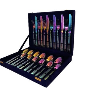 Può includere: Un set completo di posate iridescenti, tra cui forchette, coltelli e cucchiai, presentato in una custodia foderata in velluto blu scuro. Le posate presentano una finitura arcobaleno, aggiungendo un tocco di colore all'esperienza culinaria. Il set è ben disposto.