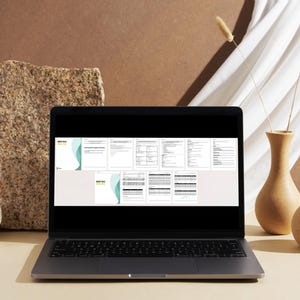 Może przedstawiać: Laptop wyświetla serię dokument&oacute;w z turkusowo-białym wzorem. Laptop jest otwarty na jasnej powierzchni, z teksturowanym kamieniem i dwoma ceramicznymi wazonami w tle. Suche łodygi znajdują się w jednym wazonie.