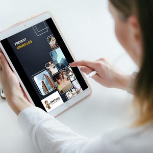 May include: A person holding a tablet displaying a "Project Issues Log" with various images. The tablet is white and gold, and a stylus is used to interact with the screen. The screen shows a dark background with white text and images.