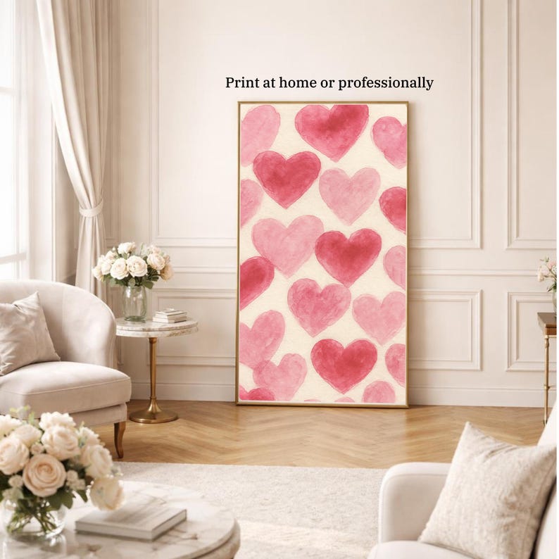May include: A framed art print featuring a pattern of pink and red watercolor hearts on a cream background. The print is displayed in a gold frame and the text "Print at home or professionally" is visible at the top.
