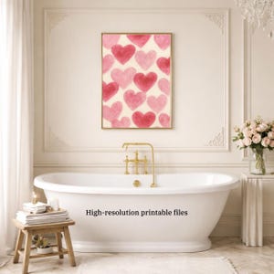 May include: A framed print featuring a pattern of pink and red hearts on a cream background. The print is displayed above a white bathtub in a bathroom setting. The text "High-resolution printable files" is visible.