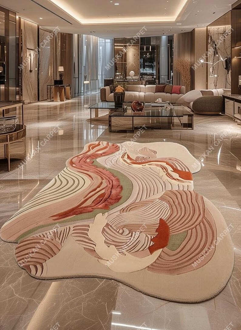 May include: A large, abstract area rug with a flowing, organic design. The rug features a palette of soft colors, including beige, peach, and muted greens, with textured patterns. The rug is placed in a modern, spacious living area.
