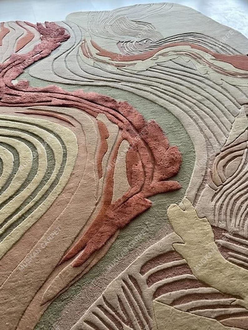 May include: A close-up of a rug with an abstract design. The rug features a blend of colors, including shades of pink, beige, and green, arranged in flowing, wave-like patterns. The texture appears soft and plush, with a detailed, carved effect.