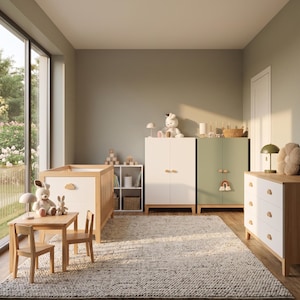 May include: A nursery room with light wood furniture, including a crib, dresser, and cabinets. The room has a neutral color palette with a large window. Decorative items include stuffed animals, a lamp, and a rug.