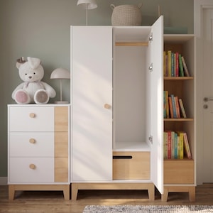 May include: A white and wood-tone nursery furniture set. The set includes a dresser with three drawers, a wardrobe with an open door, and a bookshelf filled with colorful books. A stuffed bunny sits on top of the dresser.
