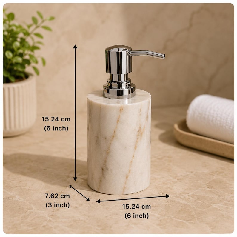 May include: A cylindrical soap dispenser made of white marble with brown veining and a polished chrome pump. The dispenser measures 15.24 cm in height, 7.62 cm in depth, and 15.24 cm in width as indicated by the visible measurement labels.