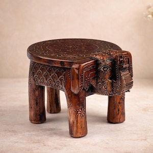 Puede incluir: Taburete de elefante de madera tallada a mano. El taburete marrón oscuro presenta un asiento redondo y cuatro patas, con diseños detallados de cabeza y cuerpo de elefante. Adecuado para la decoración del hogar. Medidas en cm.