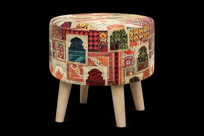 May include: A round ottoman with a patchwork design featuring various colors and patterns. The fabric-covered top rests on four light-colored wooden legs. The ottoman's design includes red, orange, green, and blue hues.