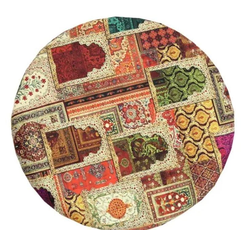 May include: A round, patterned rug featuring a patchwork design of various rectangular and square rug patterns. The rug showcases a vibrant mix of colors, including red, orange, green, and cream, with intricate floral and geometric motifs.