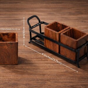Puede incluir: Juego de portautensilios de madera. El juego incluye un recipiente individual de madera y un juego doble en un marco de metal negro. El recipiente individual mide 8,1 cm de alto y 6,5 cm de ancho. El juego doble mide 23,75 cm de largo.