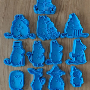 Peut inclure: Un ensemble de onze emporte-pièces en plastique bleu vif représentant divers personnages Moomin. Le lot comprend des figurines de Moominmamma, Moominpappa, Moomintroll, Snorkmaiden, Little My, Snufkin et d'autres personnages dans diverses poses.