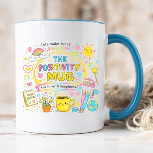 Puede incluir: Taza de cerámica blanca con asa y borde azules, con ilustraciones y texto coloridos. La taza dice "The Positivity Mug" y "Fill it with happiness!" con un arcoíris, un sol y otros gráficos alegres.