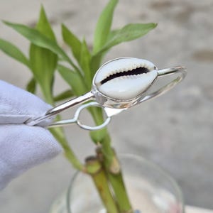 Verstelbare armband van handgemaakte sterling zilveren kauri schelpen.