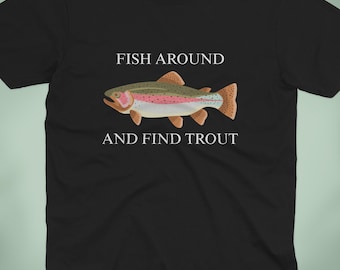 May include: Black t-shirt featuring a colorful illustration of a trout with the text "FISH AROUND AND FIND TROUT". The design includes a detailed depiction of the fish with various colors. The shirt is a classic crew neck.