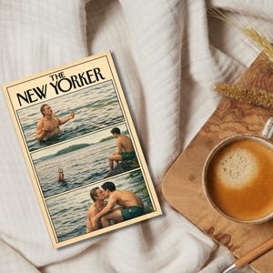 Könnte beinhalten: Ein Print im Vintage-Stil eines New Yorker-Magazin-Covers mit einem Comicstrip von zwei Männern in einem See. Der Druck hat einen cremefarbenen Hintergrund. Eine Tasse Kaffee und ein Stift liegen auf einem Holzbrett.