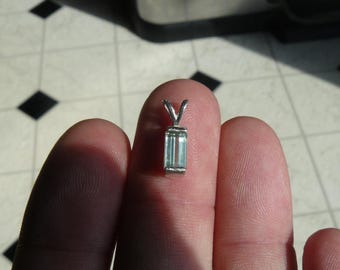 May include: A silver pendant featuring a clear, rectangular emerald-cut gemstone.