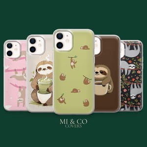 May include: A collection of five phone cases with sloth designs. The cases feature various sloth illustrations, including sloths hanging from branches, holding drinks, and resting. The cases are in shades of pink, green, brown, and black.