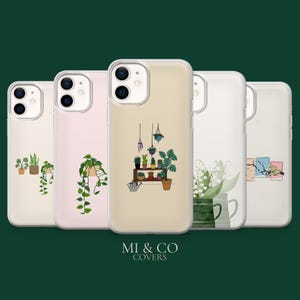 Puede incluir: Cinco fundas para teléfono con diseños de plantas. Las fundas transparentes presentan ilustraciones de plantas, incluyendo plantas colgantes y en macetas. Las fundas están alineadas sobre un fondo verde oscuro. El texto "MI & CO COVERS" está en la parte inferior.