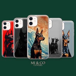 Op de afbeelding: Een verzameling telefoonhoesjes met illustraties van Dobermann Pinscher honden. Elk hoesje toont een uniek artistiek ontwerp, met levendige kleuren en verschillende achtergronden, waaronder een golf en een zonsondergang. De hoesjes worden gepresenteerd tegen een donkergroene achtergrond.