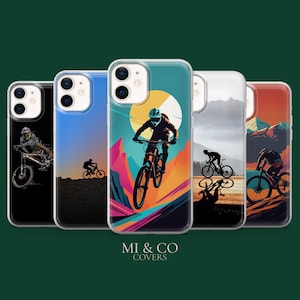 May include: A collection of five phone cases featuring mountain biking designs. Each case showcases a different illustration of a cyclist on a mountain bike, set against various landscape backgrounds. The cases are in a row, with the brand name "MI & CO COVERS" at the bottom.