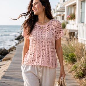 May include: A light pink short-sleeved top featuring an open crochet knit pattern with vertical columns and a round neckline, paired with beige drawstring trousers that have a visible knotted cord detail at the center of the waistband.