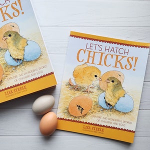 May include: Two colorful children's books with the title "Let's Hatch Chicks!" and illustrations of chicks hatching from eggs. The books are on a white surface with two brown eggs.