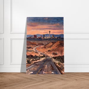 May include: A vertical painting depicting a desert highway leading towards the Las Vegas skyline at sunset. The scene features warm orange and purple sky tones, rugged brown terrain, and the distant silhouette of city buildings and the Stratosphere tower.