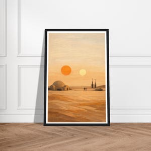 Può includere: Stampa artistica incorniciata raffigurante un paesaggio desertico con due soli, una struttura a cupola e torri distanti. La tavolozza dei colori presenta toni caldi di arancione, marrone e beige, creando una scena serena e ultraterrena. L'opera d'arte è esposta in una cornice nera.