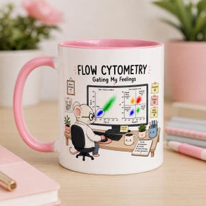Könnte beinhalten: Ein weißer Keramikbecher mit rosa Henkel und rosa Innenrand. Das Design zeigt eine Cartoon-Maus, die an einem Schreibtisch sitzt und am Computer Durchflusszytometrie-Daten analysiert. Der Text lautet FLOW CYTOMETRY Gating My Feelings, ergänzt durch wissenschaftliche Beschriftungen und eine To-Do-Liste.