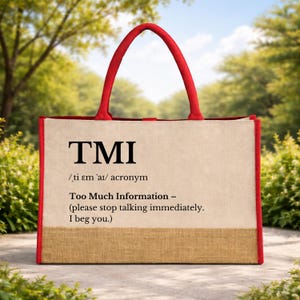 May include: A beige tote bag with red handles and trim. The bag features the acronym "TMI" in black, with the definition "Too Much Information" below. The bag is made of a natural fiber material.