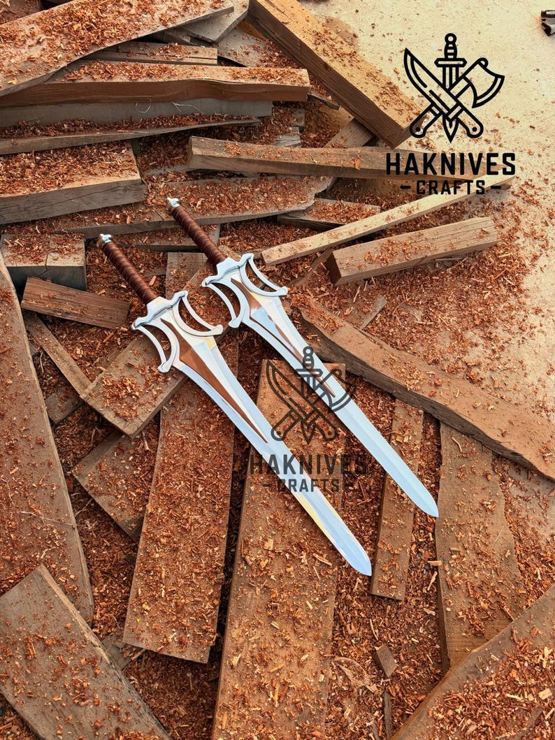 May include: Two decorative swords with silver blades and brown handles rest on a bed of wood shavings and planks. The swords have ornate, stylized hilts. The image includes the text "HAKNIVES CRAFTS" and a logo featuring a knife and axe.