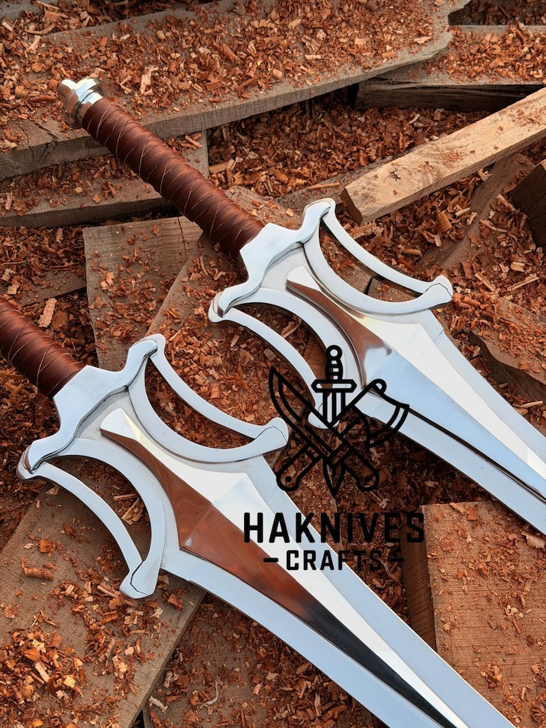 May include: Two silver swords with brown leather-wrapped handles and a copper-colored blade insert. The swords are displayed on a wooden surface with the text "HAKNIVES CRAFT".