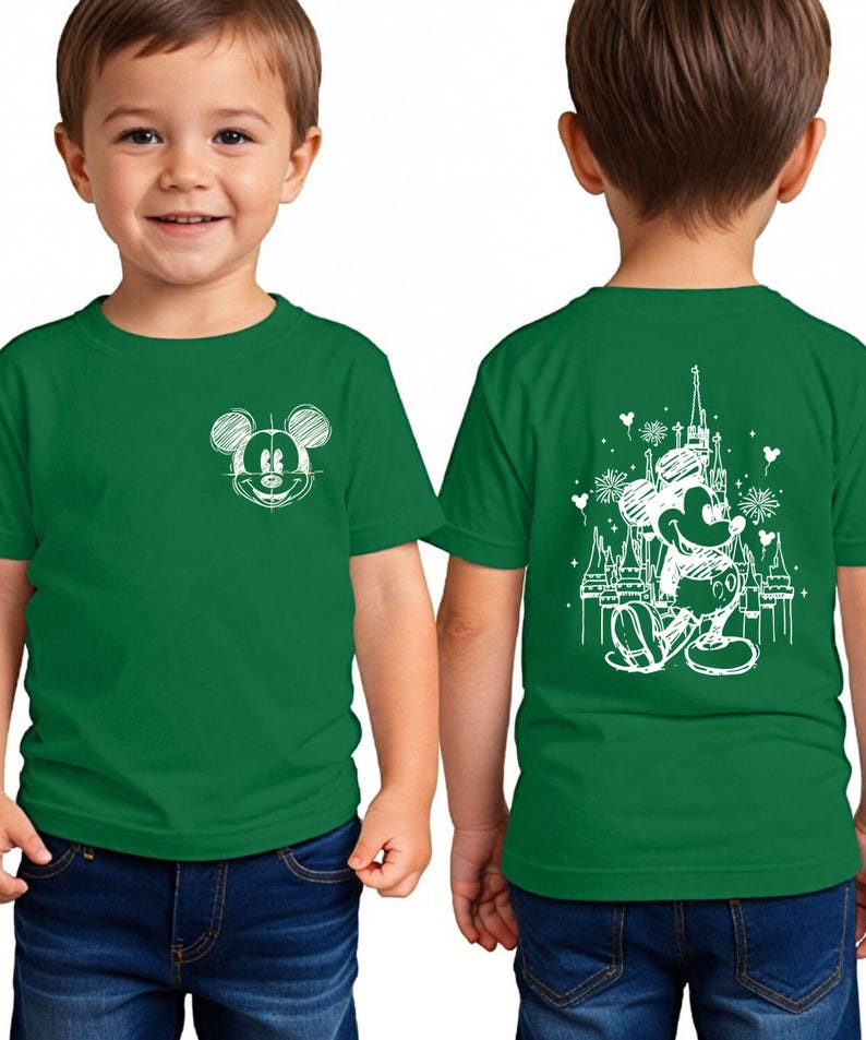 A young boy wearing a green t-shirt with a Mickey Mouse design on the front and back.