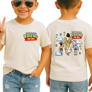 A young boy wearing a white t-shirt with a graphic design and text on the back, smiling and making a peace sign.