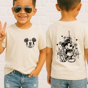 A young boy wearing a Mickey Mouse t-shirt and sunglasses, smiling and making a peace sign.