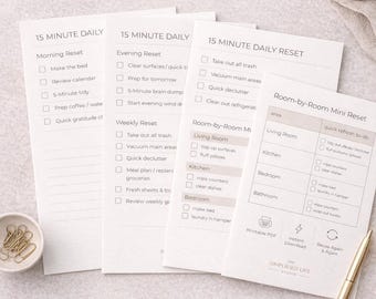May include: A collection of printable checklists titled "15 Minute Daily Reset" and "Room-by-Room Mini Reset." The checklists are designed to help organize daily, evening, weekly, and room-specific tasks. A gold pen and paperclips are also visible.