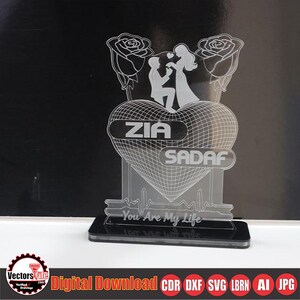 May include: A clear acrylic LED lamp featuring a heart-shaped design with the names "ZIA" and "SADAF". The lamp includes a silhouette of a couple and roses, with the text "You Are My Life".