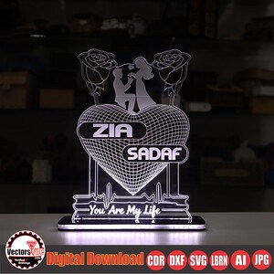 May include: A lighted heart-shaped decorative piece with the names "ZIA" and "SADAF". The design includes a couple, roses, and the text "You Are My Life". The base has a rectangular shape. The image also includes the text "Digital Download CDR DXF SVG LBRN AI JPG".