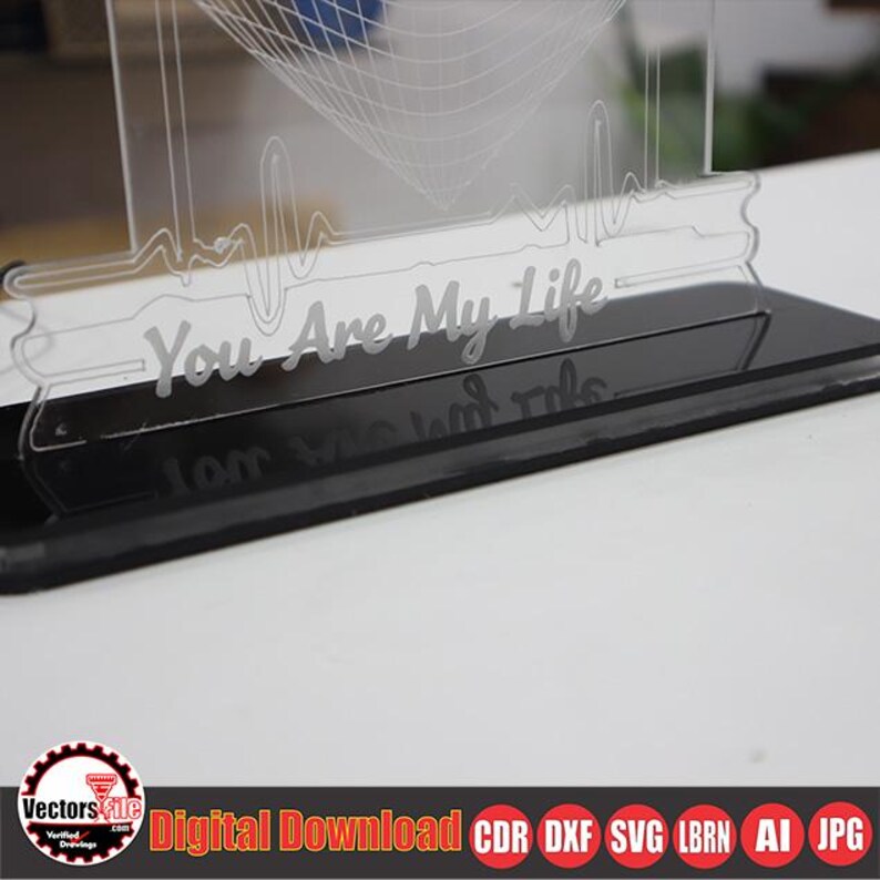 May include: A clear acrylic LED night light with the phrase "You Are My Life" etched on the front. The base is black and rectangular. The design includes a heartbeat line and a geometric shape.