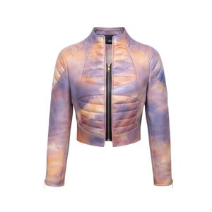 May include: A cropped, quilted jacket with a vibrant, watercolor-like design in shades of purple, orange, and blue. The jacket features a stand-up collar, long sleeves, and a full-length black zipper. The sleeves have zippers at the cuffs.
