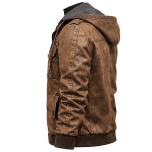 May include: Brown faux leather jacket with a grey hooded lining. The jacket features multiple pockets, a ribbed hem, and cuffs. The jacket is designed with a vintage, distressed look.