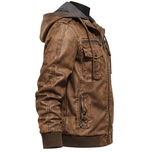 May include: Brown faux leather jacket with a grey hooded insert. The jacket features multiple pockets, a zip closure, and ribbed cuffs and hem. The jacket is designed with a distressed finish.