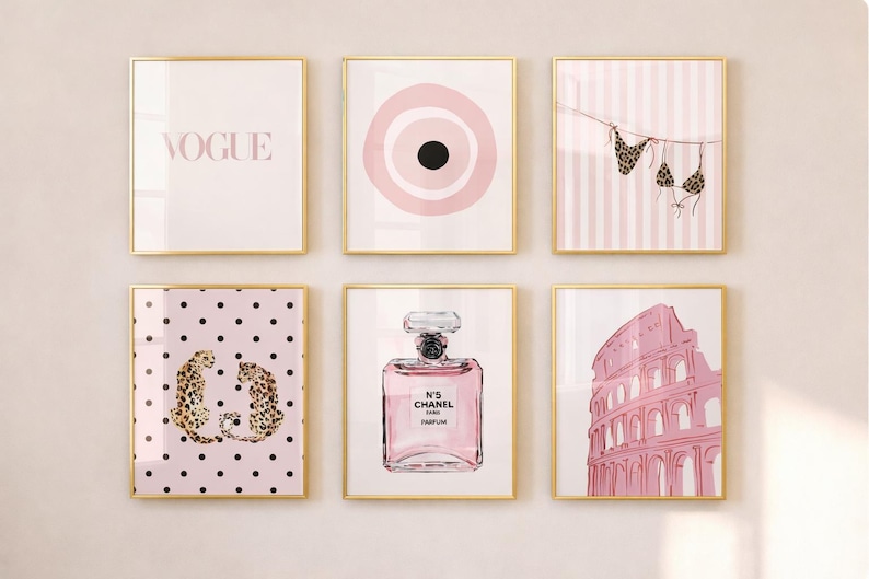 May include: Six framed art prints with gold frames. The prints feature various pink and gold designs, including the word "VOGUE", a target, a bikini, leopard print, a perfume bottle, and the Colosseum.