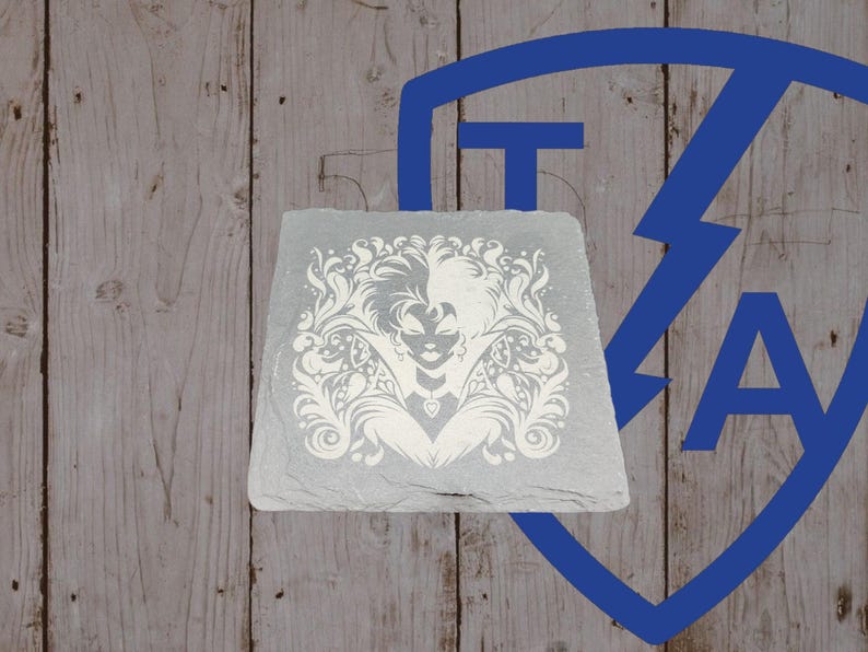 May include: A square, gray slate coaster with a white, ornate design featuring a woman's face and floral elements. The coaster is set against a wooden background with a blue graphic.