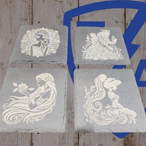 May include: Four gray slate coasters with white etched designs. Each coaster features a different princess: Elsa, Belle, Rapunzel, and Jasmine. The coasters are square with a slightly angled edge, perfect for drinks.