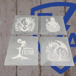 May include: Four square slate coasters with white etched designs. The designs include a villainous woman, a sea witch, a dragon with a woman, and a character with the text "pull the lever KRONK". The coasters are on a wooden background.