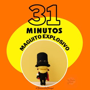 Op de afbeelding: Gehaakte pop in een zwarte outfit met een rode cape en hoge hoed, tegen een gele cirkel op een oranje achtergrond. De tekst "31 MINUTOS MAGUITO EXPLOSIVO" staat boven de pop.