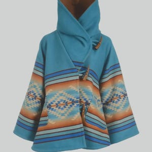 May include: A turquoise hooded poncho with a Southwestern-inspired geometric pattern in shades of orange, tan, and blue. The poncho features wooden toggle closures and a brown lining inside the hood.
