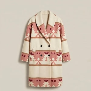 May include: A double-breasted coat with a cream-colored base and a geometric pattern in shades of pink and brown. The coat features a wide lapel, two rows of black buttons, and two front pockets. The coat is a long length.