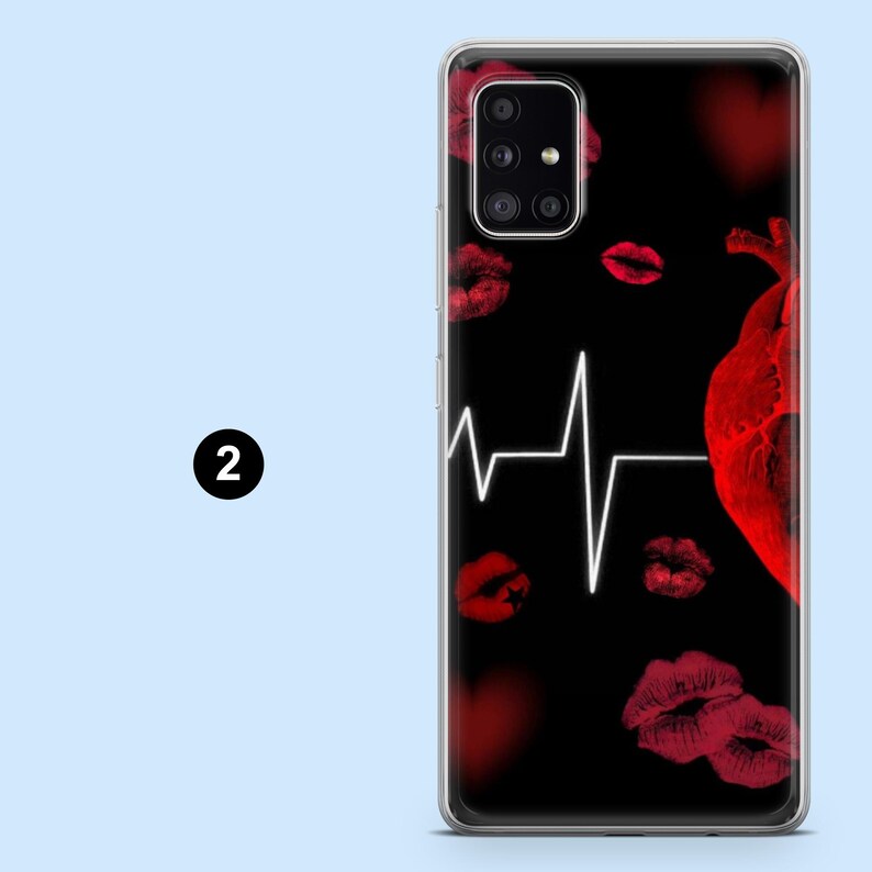 Puede incluir: Funda de tel&eacute;fono negra con un dise&ntilde;o de coraz&oacute;n rojo, marcas de besos de l&aacute;piz labial rojo y una l&iacute;nea de ECG blanca. La funda tiene un borde transparente.